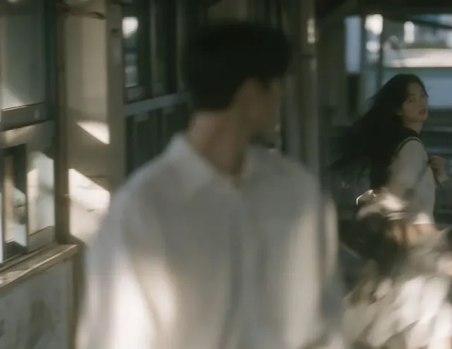 Blurred schoolboy close to the camera with a girl farther along a softly lit school corridor