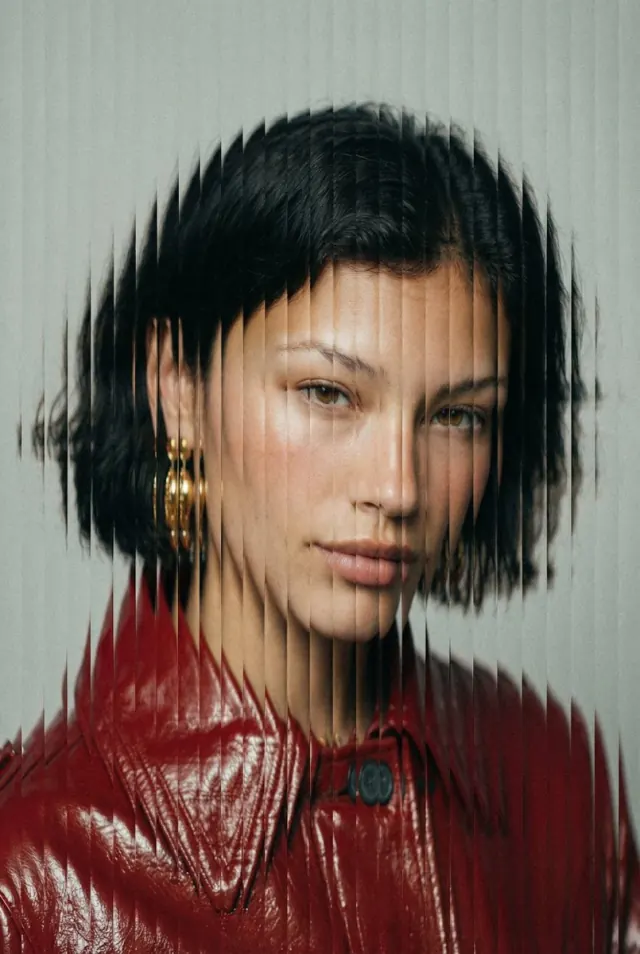 Fashion portrait of a woman with a glossy black bob interrupted by narrow vertical image slices