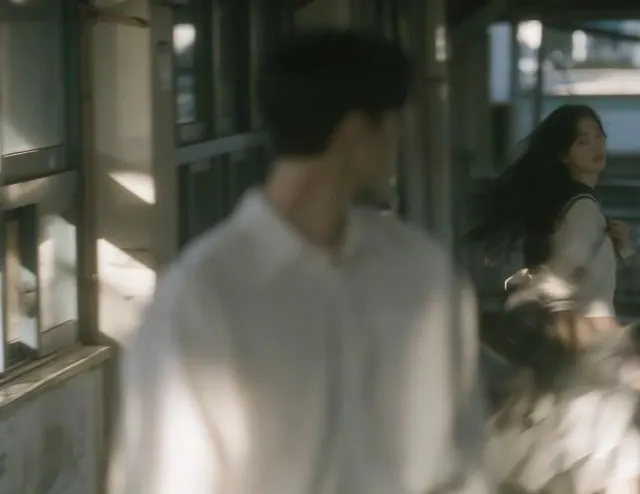 Blurred schoolboy close to the camera with a girl farther along a softly lit school corridor