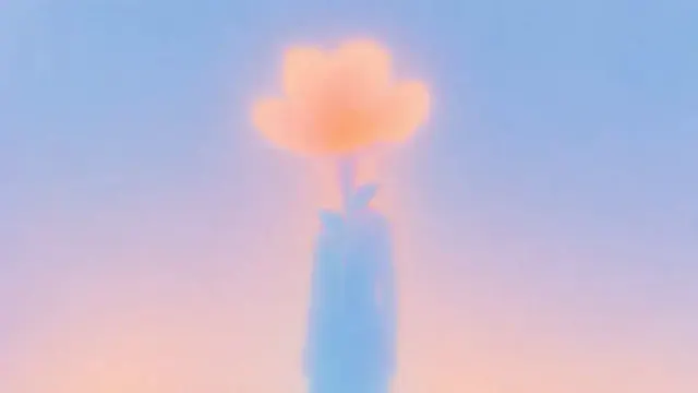 Translucent cobalt vase holding a peach cloud shaped flower against a hazy pastel blue and pink background